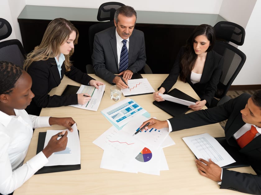 Employees discussing profits around a conference table