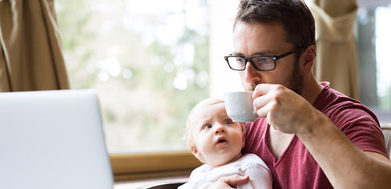 Father at computer with baby in lap